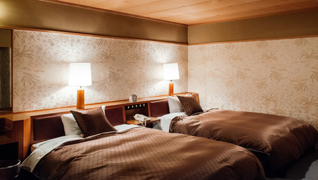 MAY 25, 2013 Gifu, JAPAN - Vintage Japanese hotel bedroom with warm light and atmosphere from bed lamps. Decorated with retro vintage wallpaperのeditorial素材