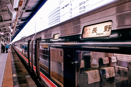 MAY 30, 2013 Nagoya, Japan - Shinano train with Nagano destination sign stop at platform of JR Chuo Main line at Nagoya station with Japanese passengers walking behind yellow lineのeditorial素材