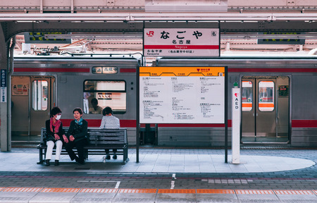 MAY 30, 2013 Nagoya, Japan - Passengers waiting at platform of JR Nagoya station with station sign and local train in background - vintage film style imageのeditorial素材