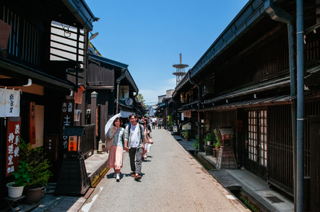 MAY 27, 2013 Takayama ,Gifu, Japan - Young asian couple with umbrella walking on street at Sanmachi Suji old Edo district, famous shopping and tourist attraction of Takayama old town.のeditorial素材