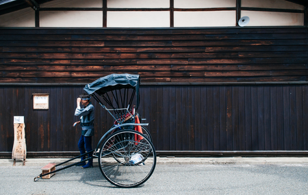 MAY 27, 2013 Takayama ,Gifu, Japan - Old vinatge Sanmachi Suji old Edo district of Takayama with Japanese pulled rickshaw and old wood wall, famous Takayama old town.のeditorial素材