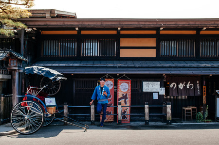 MAY 27, 2013 Takayama ,Gifu, Japan - Old vintage Sanmachi Suji old Edo district of Takayama with Japanese pulled rickshaw and old wood house, famous Takayama old town.のeditorial素材