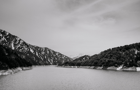 Toyama, Japan - Nature scene on Kurobe dam, lake and snow mountain on cloudy day. A Part of Tateyama Kurobe Alpine routeの写真素材