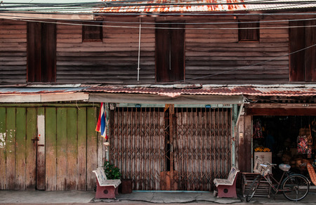 FEB 28, 2013 Songkhla, TAHILAND - Vintage bike and local old wooden house at Songkhla Nang Ngam street famous historic district in summer.のeditorial素材