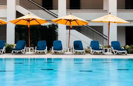 APR 26, 2013 Phuket, Thailand - Resort style Vacation Relaxation resort pool bed under yellow umbrellas by the pool under bright summer sunのeditorial素材