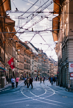 SEP 28, 2013 Bern, Switzerland - Old vintage Marktgasse street scene with tourist walking. Famous old town area and shopping streetのeditorial素材