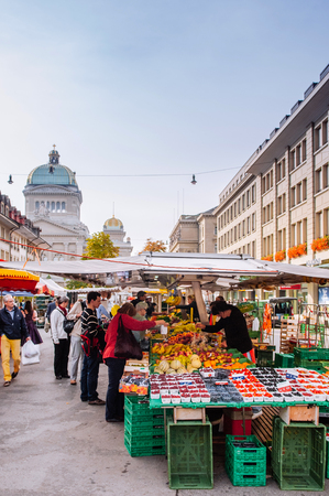 SEP 28, 2013 Bern, Switzerland - Swiss people buying fruit at local Vegetable and fruit shop in morning market Bundesplatz in front of Swiss Parliament building.のeditorial素材
