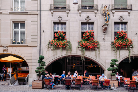 SEP 27, 2013 Bern, Switzerland - European tourists having lunch in street restaurant with outdoor...