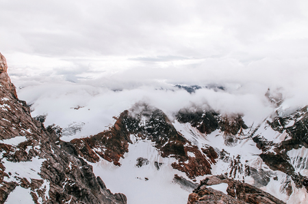 Rock cliff  rise high behind cloud and deep snow mountain valley of Titlis in Engelberg, Switzerland