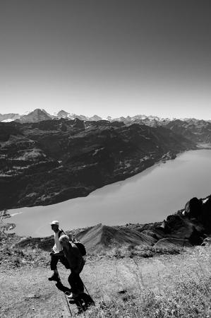 SEP 23, 2013 Entlebuch, Switzerland - Tourists hiking on mount Brienzer Rothorn with Swiss Alps under afternoon sunlight and lake Brienz viewのeditorial素材