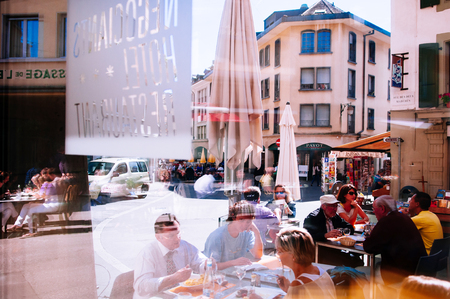 SEP 25, 2013 Vevey, Switzerland - Tourists enjoy outdoor luch with Beautiful vintage buildings in old town area of famous Vevey cityのeditorial素材