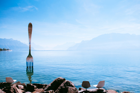 SEP 25, 2013 Montreux, Switzerland - Lake Geneva shore with The Fork of Vevey modern installation art with Swiss alps view on bright sky day in autumnのeditorial素材