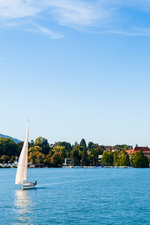 Zurich, Switzerland - Peaceful lake shore and beautiful white sailing boats in lake Zurich on clear sky day in early autumnの写真素材
