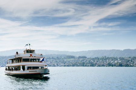 SEP 22, 2013 Zurich, Switzerland - Sightseeing cruise ship and beautiful peaceful scenery of lake Zurich on clear sky dayのeditorial素材