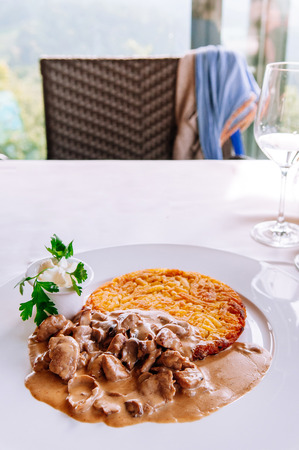 Zurich style veal meat stew with creamy mushroom gravy sauce and fried rosti potato, Local Swiss cuisine in white plateの写真素材