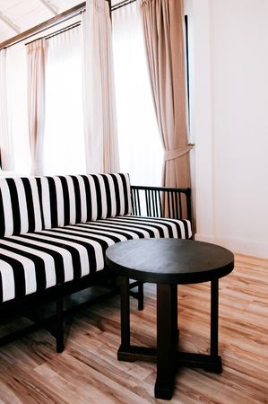 FEB 10, 2014 Chiang Mai, THAILAND - Black and white strips pattern armchair and old wood table contemporary style living room white wall with curtain and natural lightのeditorial素材