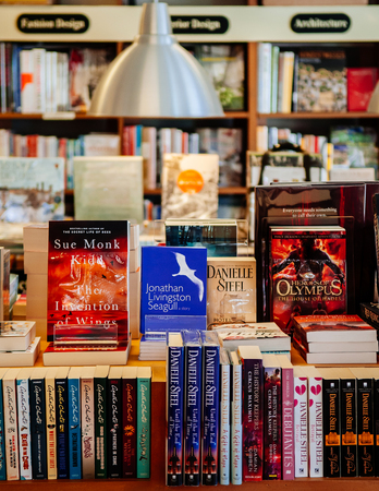 FEB 12, Chiang Mai, THAILAND - Various book collections on wooden shelf with large modern lamp hanging above in small bookstoreのeditorial素材