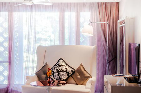 MAR 13, 2014 Bangkok, THAILAND - Vintage luxury interior vintage white leather sofa couch with floor lamp, round table and carpet, Vintage sweet luxury home decorating design natural light through curtainのeditorial素材
