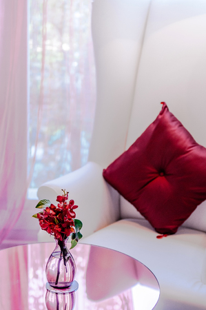 MAR 13, 2014 Bangkok, THAILAND - Nice flower in glass bottle on round table with armchair and pillow in background, Vintage sweet luxury home decorating itemのeditorial素材