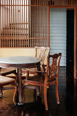 AUG 4, 2014 Bangkok, Thailand - Oriental chinese vintage wooden furniture, chairs, round marble table in old house with wood floorのeditorial素材