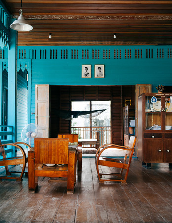 AUG 6, 2014 Bangkok, Thailand - Vintage wooden furniture, chairs, table, wood cabinet in old Thai country house with hard wood floor and bright coloured wallのeditorial素材