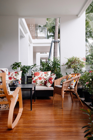 AUG 6, 2014 Bangkok, Thailand - Oriental Thai vintage furniture, wood chair, rattan chair, table and sofa couch at garden balcony with wood floor, natural light.のeditorial素材