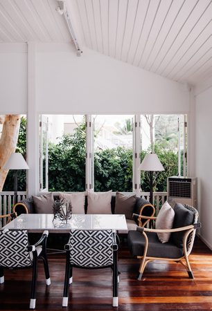 AUG 7, 2014 Hua Hin, Thailand - Tropical modern beach house white tone wood floor living room interior with well design chairs, table and lamps with garden viewのeditorial素材