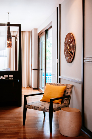 AUG 6, 2014 Hua Hin, THAILAND - Colourful modern furniture, wood chairs and side table in Asian style hotel room with wooden decorating itemsのeditorial素材