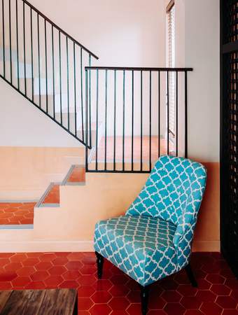 Asian Living room with red tile floor, modern furnitures, colourful armchairs in front of staircase.の写真素材