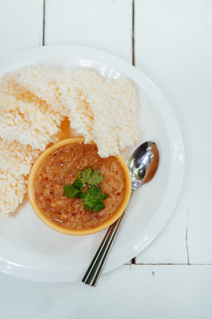 Thai crispy rice cake with shrimp tammarind peanut sauce - Thai traditional snack in white plate on white table. Top view shotの写真素材