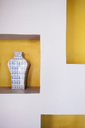 AUG 4, 2014 Hua Hin, THAILAND - Antique Blue and white Chinaware flower vase, Chinese porcelain on yellow and white wall backgroundのeditorial素材