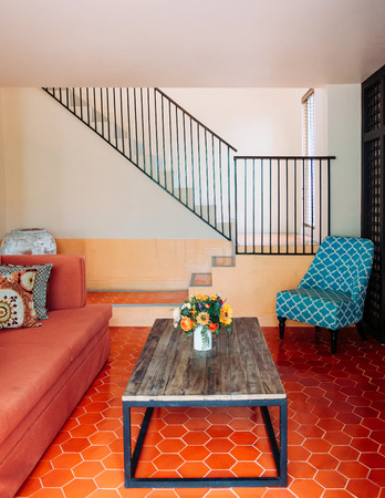 AUG 4, 2014 Hua Hin, THAILAND - Red fabric sofa couch, Asian style pillows, old wood table and colourfu;l armchair in living room. Cozy contemporary home interior furnituresのeditorial素材