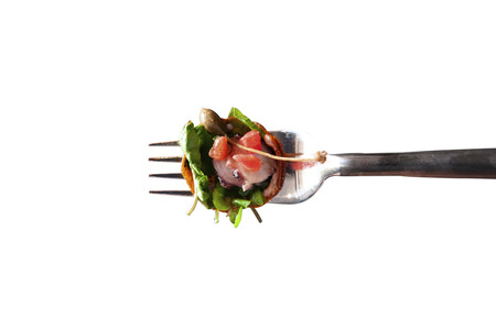 Fresh octopus carpacio with citrus spinach salad pesto balsamic dressing on silver fork, isolated on white backgroundの写真素材