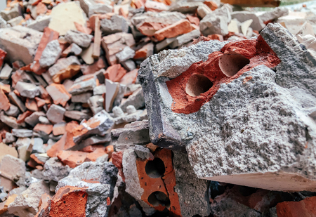Pile of Broken red brick and concrete at construction site close up details - ruin destruction...