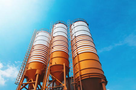 Cement silos of Cement batching plant factory against afternoon sun with clear blue skyの写真素材