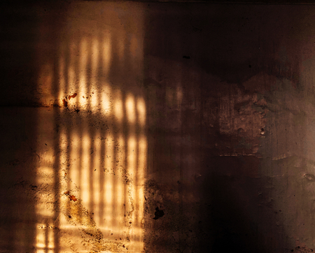 High contrast light and shadow strips on old grungy dirty concrete wallの写真素材
