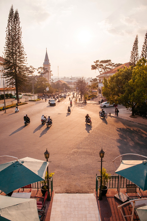 FEB 26, 2014 Dalat, Vietnam - Warm sunset light silhouette motorcycle traffic in evening at Da Lat Cathedral with Purple orchid treeのeditorial素材