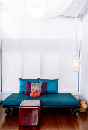 MAY 22,2014 Koh Lanta, Krabi, Thailand - White modern minimal living room interior with colorful furnitures, blue sofa couch with asian style pillows and red acrylic table. Modern simple and clean interior designのeditorial素材