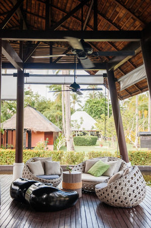 MAY 21, 2014 Krabi, THAILAND - Modern contemporary tropical Asian style sofa couch, pillows at hotel lobby with garden view in backgroundのeditorial素材