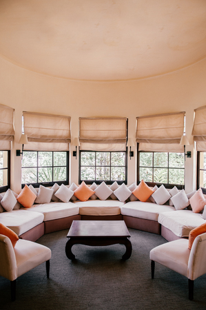 FEB 25, 2014 Dalat, Vietnam - Vintage colonial tropical country house living room classic sofa couch, old wood table, lamps, old picture frame on white wall and antique telephoneのeditorial素材