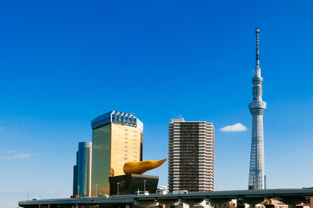 NOV 29, 2018 Tokyo, Japan - Tokyo Skytree Tower rised high against blue sky with Asahi Beer Hall in...