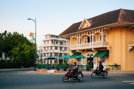 FEB 26, 2014 Dalat, Vietnam - Warm atmosphere and light traffic street evening in Da Lat city with yellow colonial buildingのeditorial素材