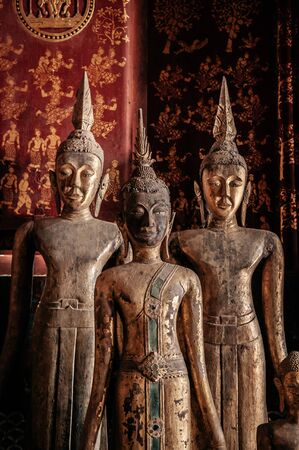 Luang Prabang, Laos - Antique old wooden and gold Buddha statues at Wat  Xieng thong museum. Most Famous tourist attractionのeditorial素材