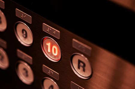 Close up elevator floor number buttons with light on selective focus