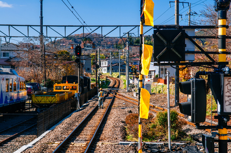 Shimoyoshida, Japan - NOVEMBER 30, 2018 : Train railway tracks junction with traffic light signal and engineer worker on inspection duty of Fujikyu railway line - Shimoyoshida station train tracksのeditorial素材