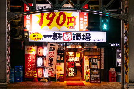 DEC 4, 2018 Tokyo, Japan - Izakaya bar and night street restaurant with neon signs under train track near Kanda JR stationのeditorial素材