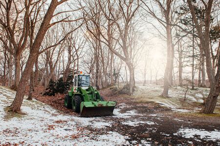 Farm Tractor under leafless tree with snow covered ground in winter. Hakodate, Hokkaido - Japanの写真素材
