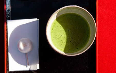 Japanese Matcha green tea in ceramic bowl on black and red tray top view food image