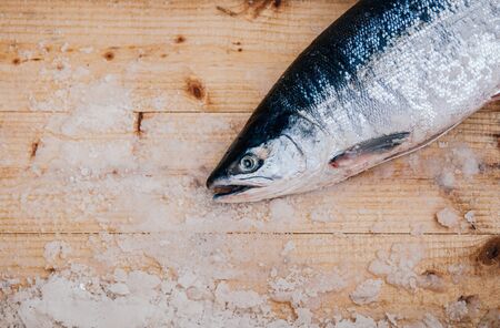 Whole fresh raw Japanese salmons with ice on wooden plate top view with copy space. Raw fish in Asaichi Morning Market, Hakodate - Hokkaidoの写真素材