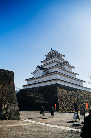 DEC 4, 2018 Aizu Wakamatsu, JAPAN - Aizu Wakamatsu Tsuruga Castle and ancient stone wall against warm sunlight. Fukushima Samurai lord fortess in Edo period